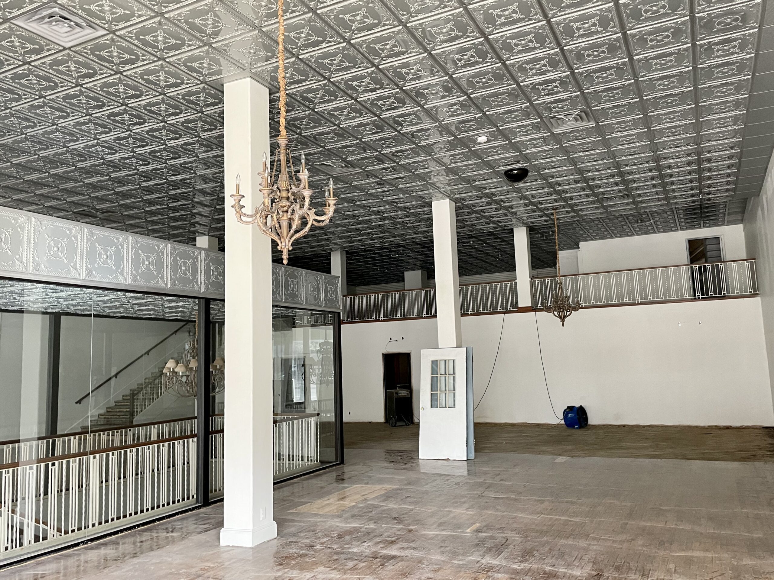 Building interior with tin ceilings and chandeliers.