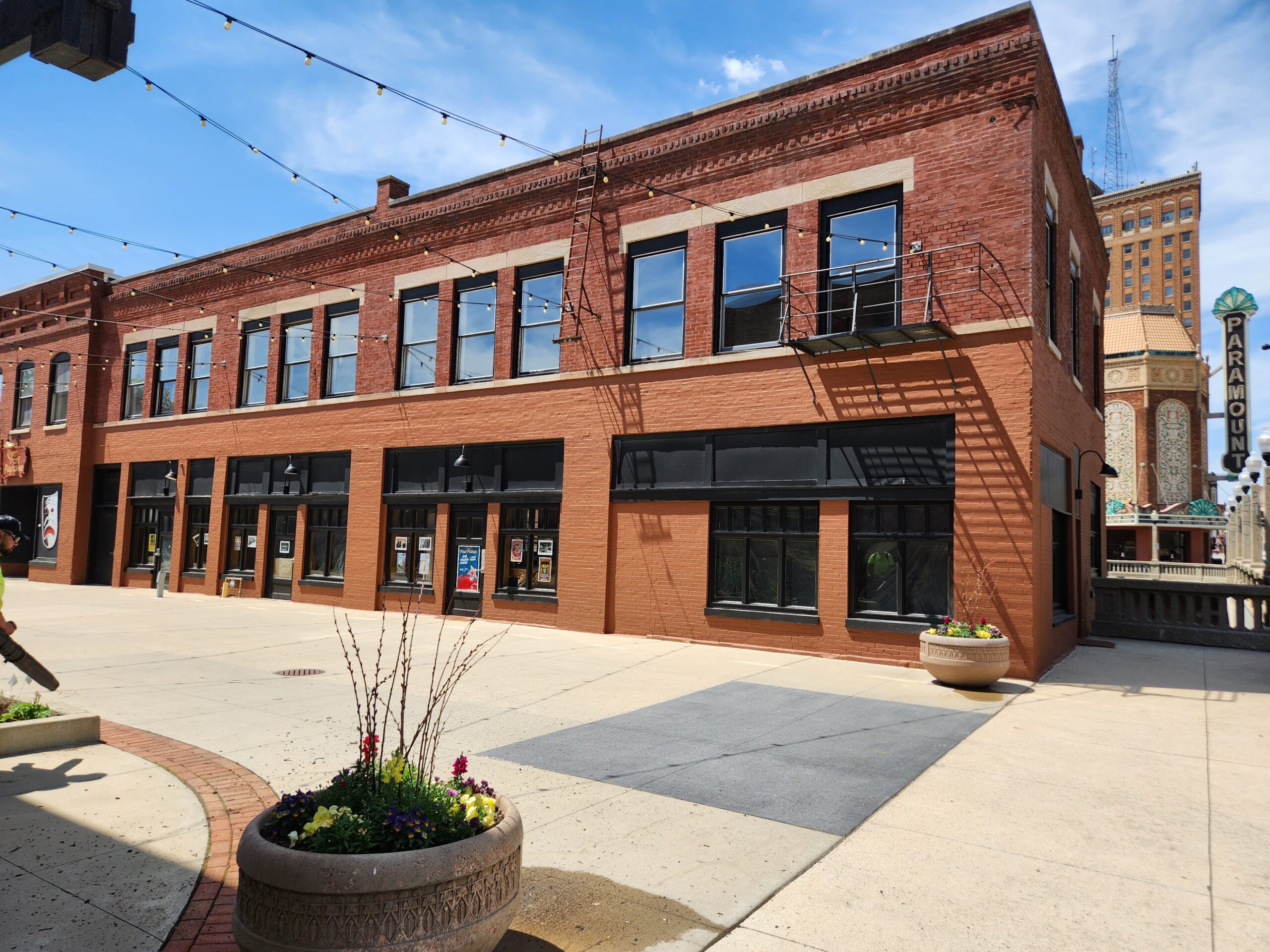 43 Galena as a plain brick building on the plaza with bistro lights above.